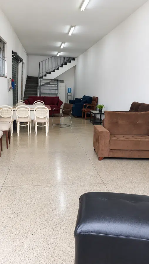Área comercial térrea com mobiliário e escada ao fundo